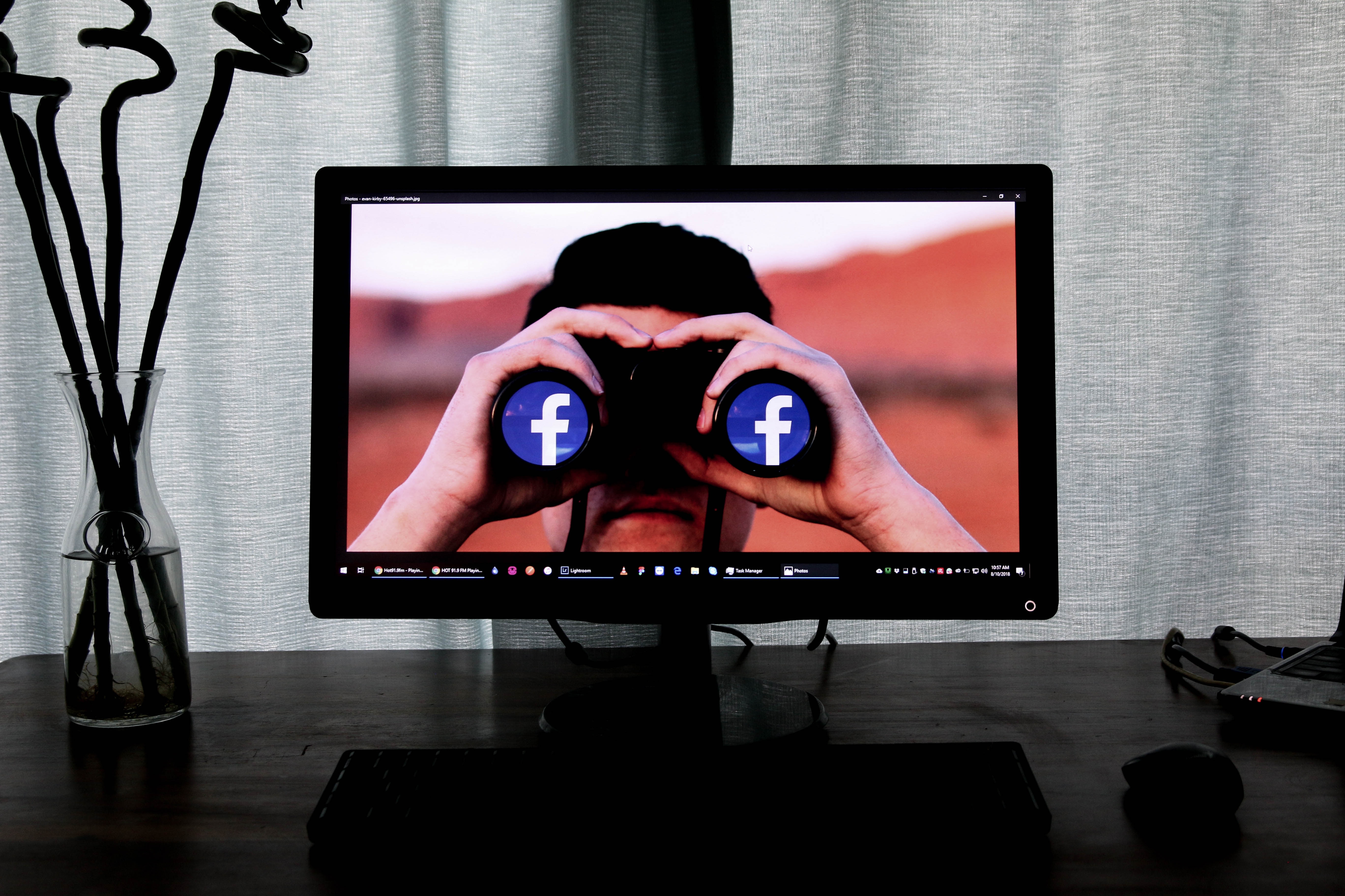 A person with a binocular with facebook logo inside a computer monitor